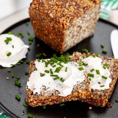 Two slices of Nut, seed & grain loaf with vegan cream cheese and chives