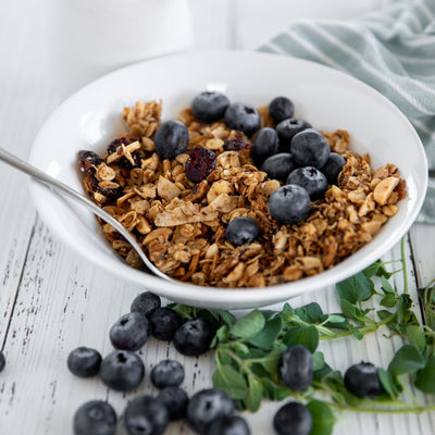 A bowl of organic healthy vegan granola with blueberries on a table