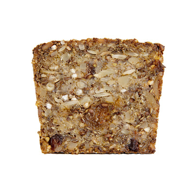 Close up of a single slice of the Gluten Free Fruit Bread. Displayed on white background with all the nuts, seeds & fruit clearly visible. Gluten Free Fruit Loaf.