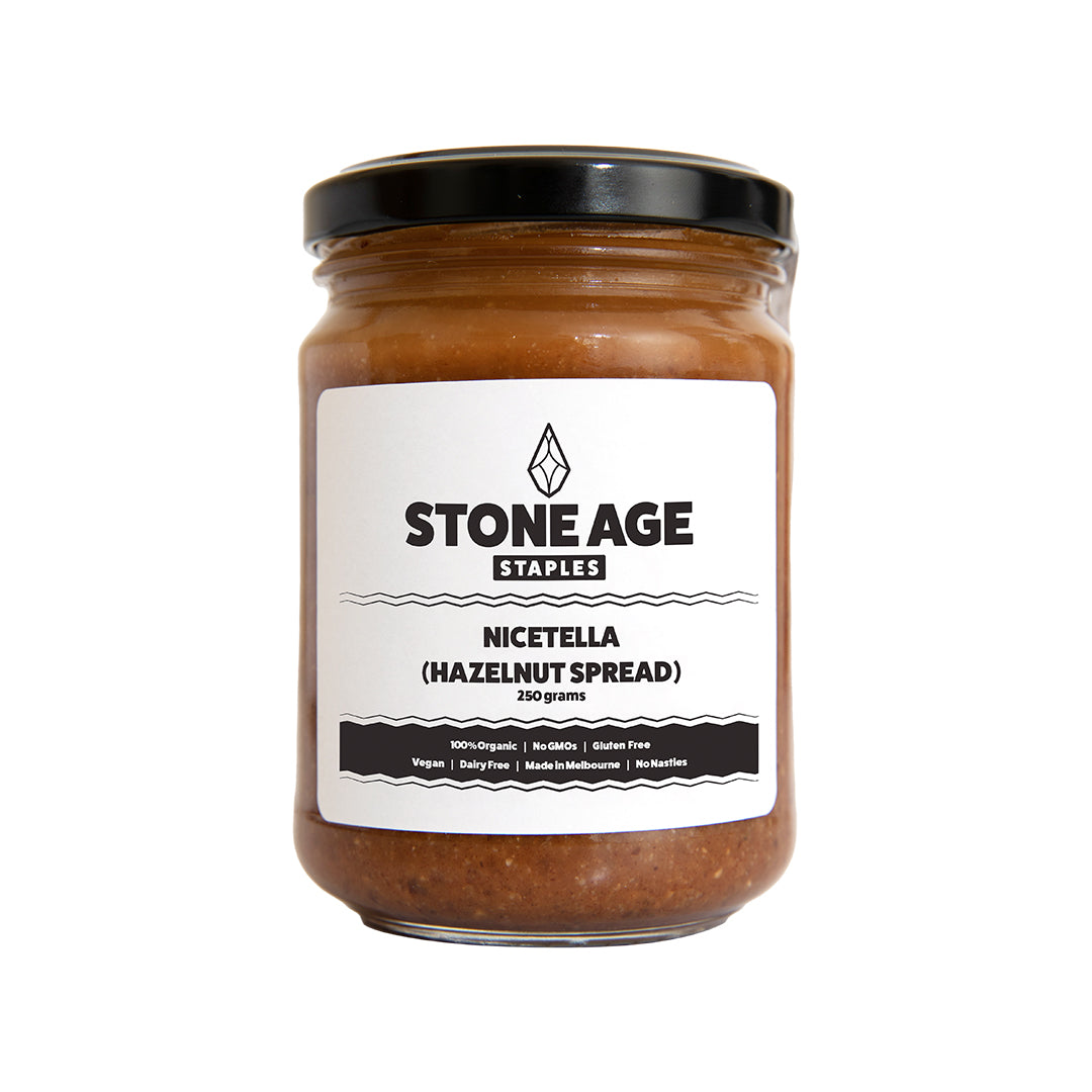 Close up shot of a jar of Nicetella or Hazelnut spread. Showing the front of the jar, including the label and dark brown, textured nut butter inside. Includes a black lid and displayed on a white background.