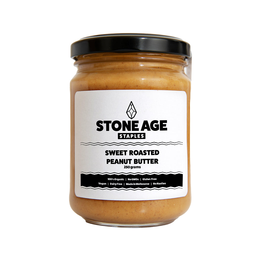 Close up shot of a jar of Sweet Roasted Peanut Butter. Showing the front of the jar, including the label and nut butter inside. Includes a black lid and displayed on a white background.